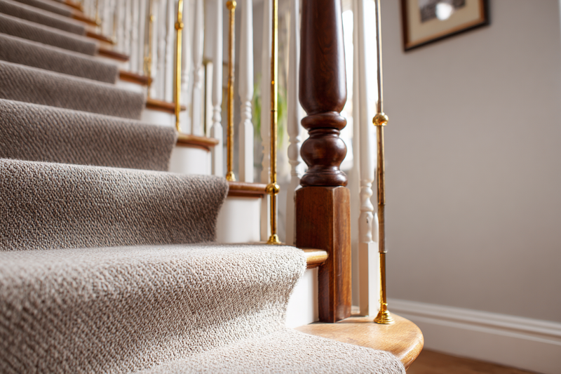 Durable carpet on an elegant staircase with brass stair rods