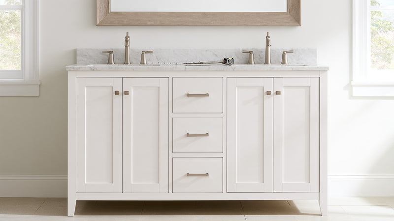 White shaker double-sink bathroom vanity with a marble top seen straight on against the full wall, a tape measure on the counter