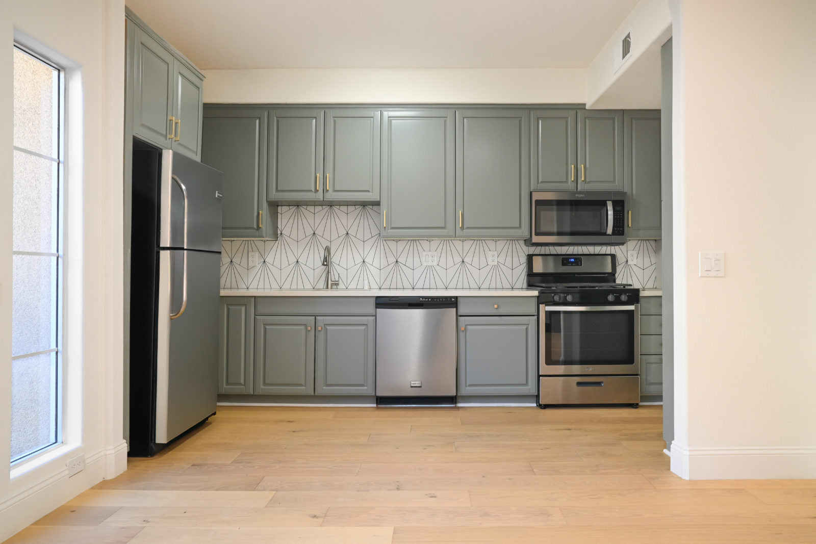 Light wide-plank Garrison Newport Manhattan Beach engineered oak flooring installed in an open-plan living space.